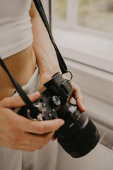 Persona sosteniendo una cámara con un fondo difuminado.