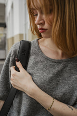 Vrouw met een zwarte tas en een wazige achtergrond