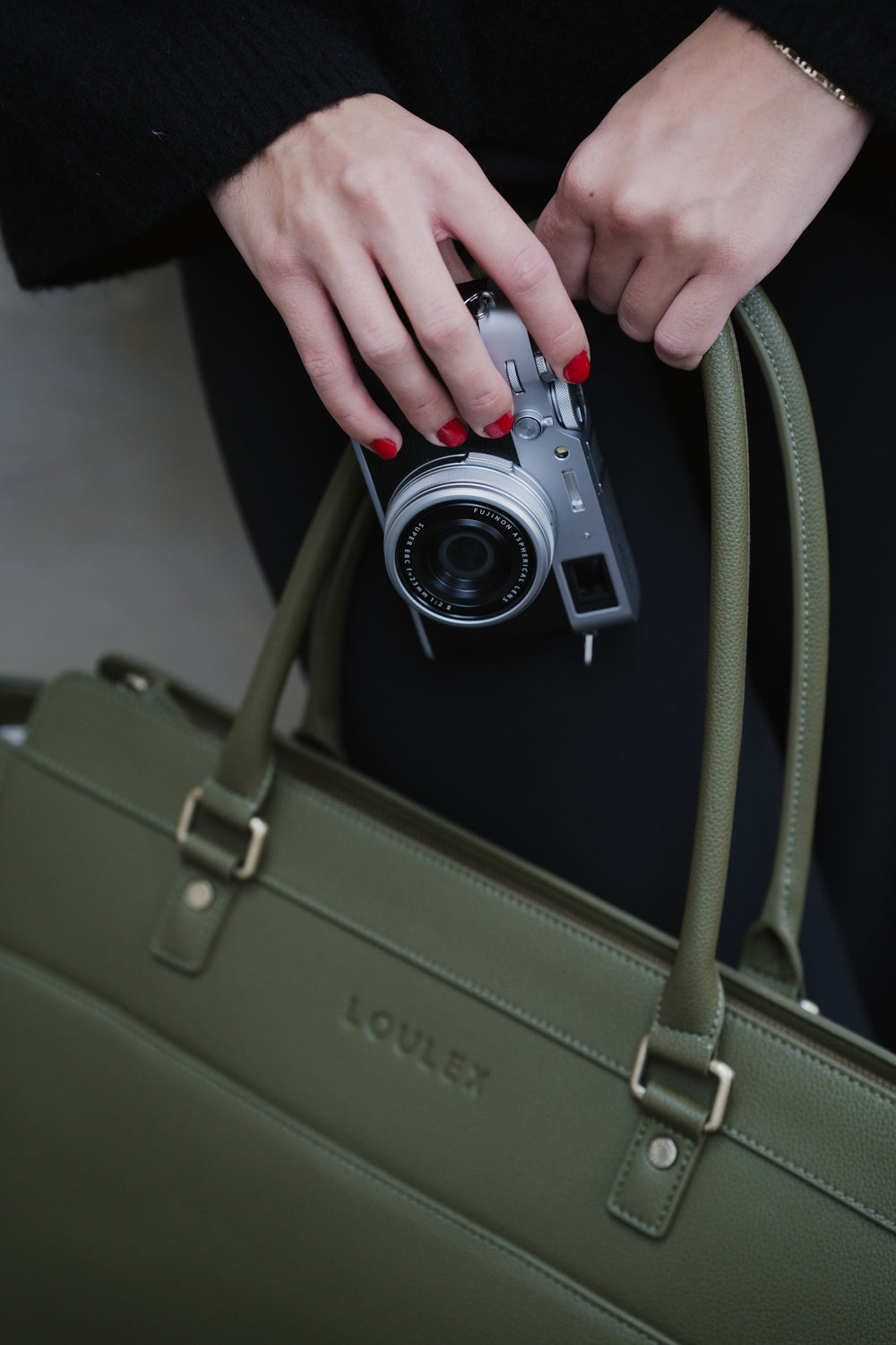 Persoon met een camera en een groene handtas op de voorgrond