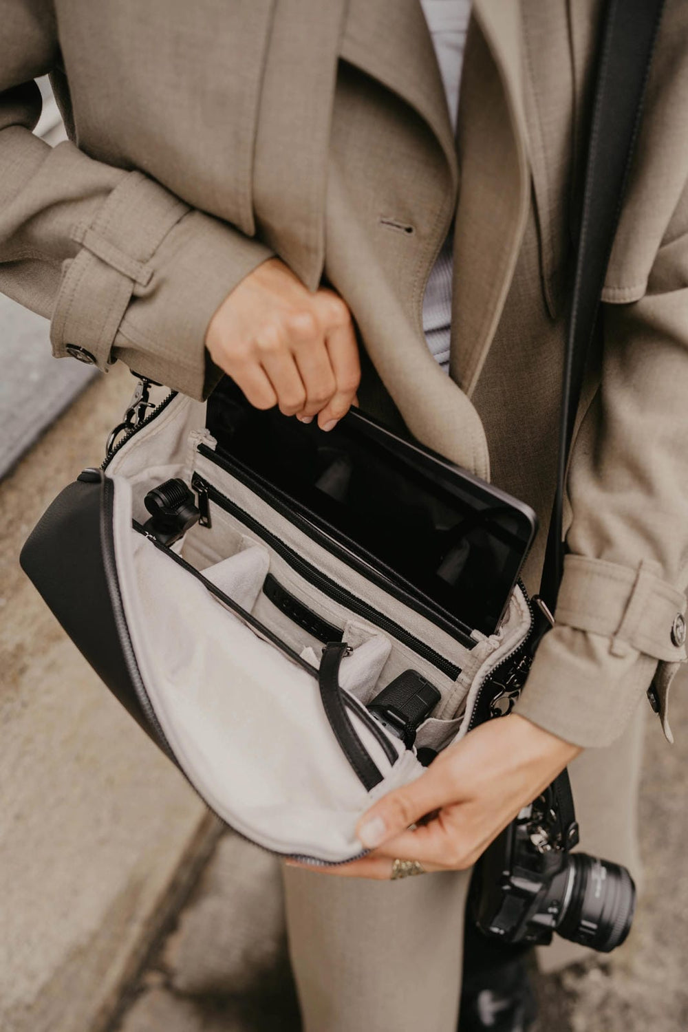 Persona con un abrigo y una bolsa con una cámara en su interior.