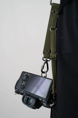 Camera met een groene riem op een effen achtergrond