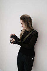 Persoon met een camera tegen een witte muur