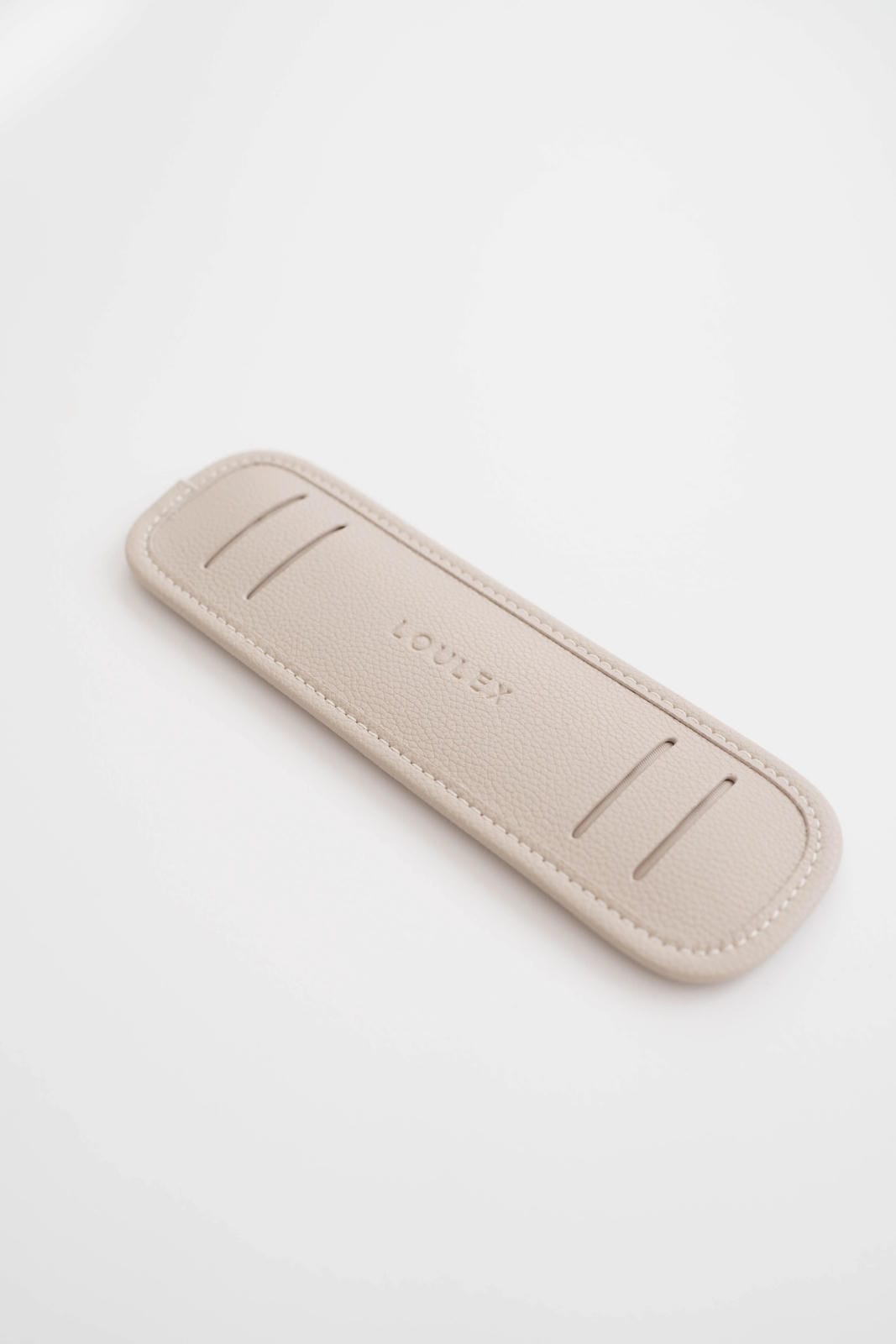 Beige leather case with 'LOVLEY' branding on a white background