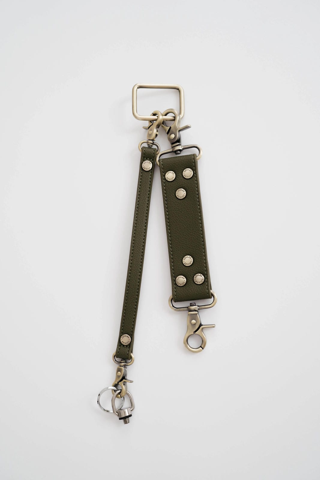 Green leather strap with metal hardware on a white background