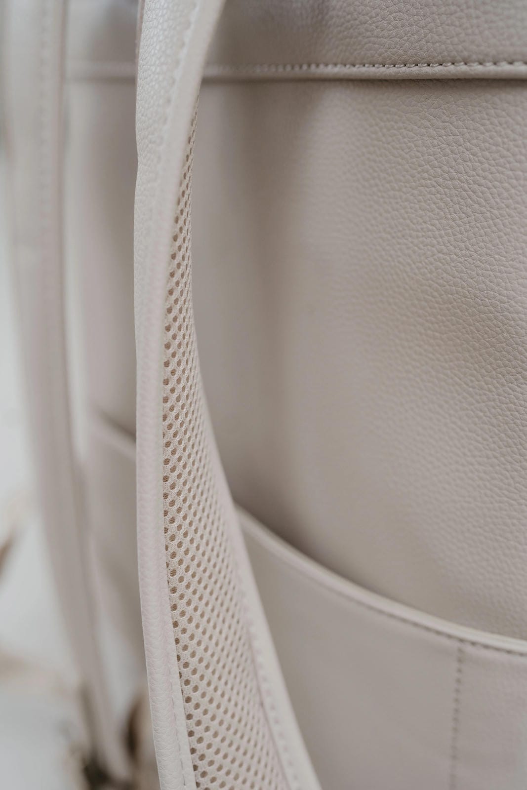 Close-up of a beige leather bag with stitching details