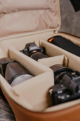Equipo fotográfico dentro de una maleta de viaje de color beige.