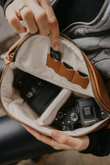 Persona che tiene una borsa con una macchina fotografica all'interno