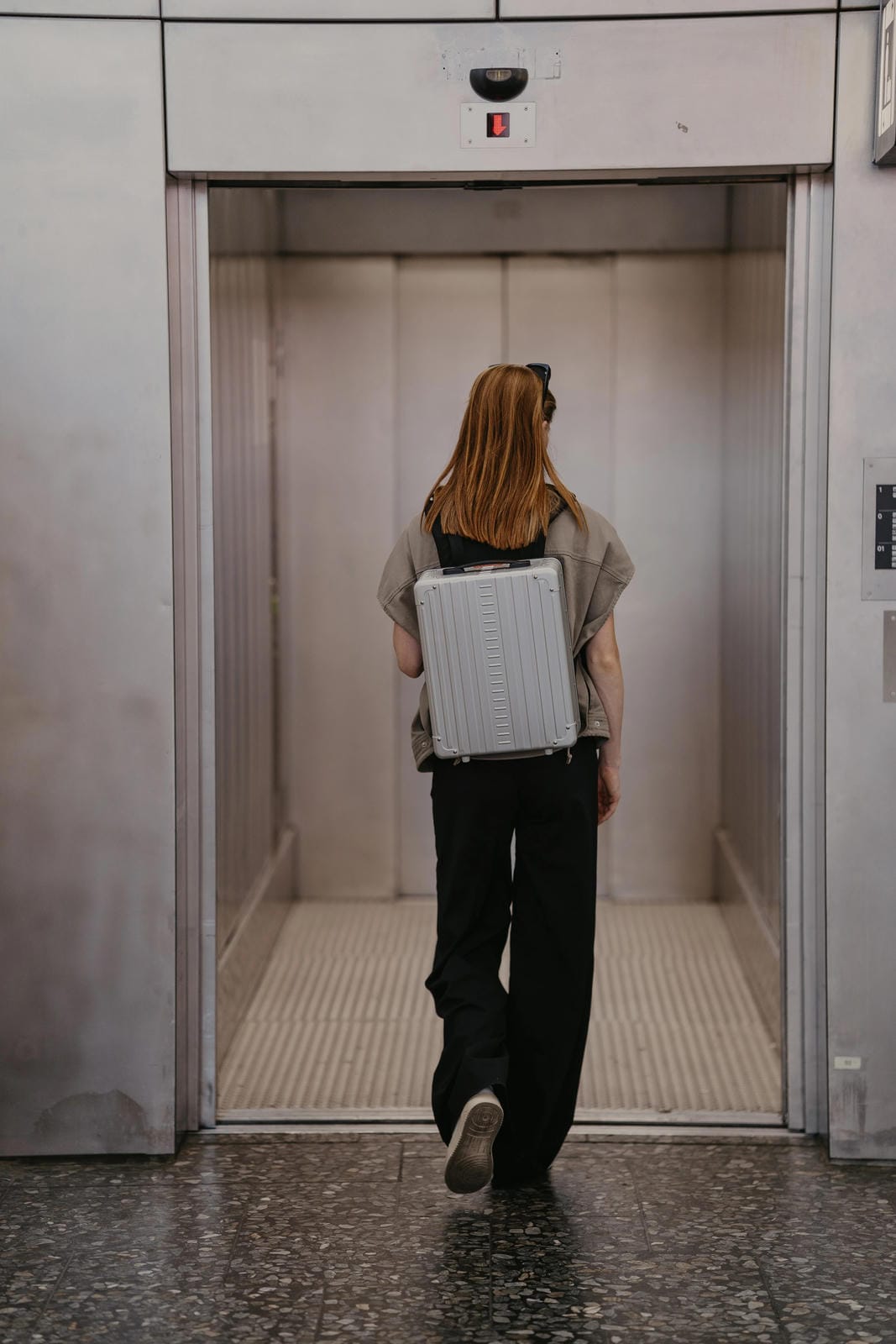 Person with a suitcase entering an elevator