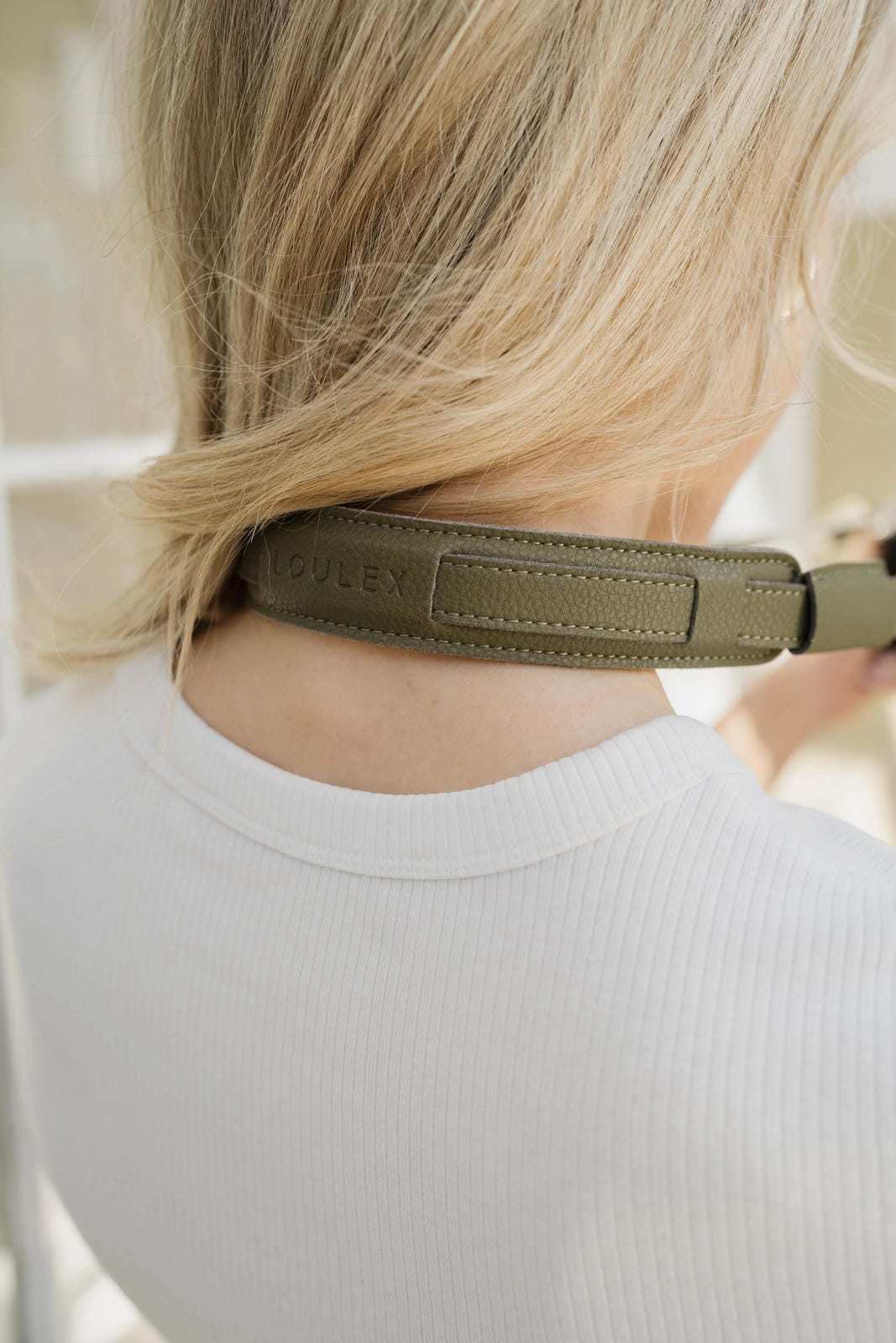 Personne portant un bandeau vert avec un logo de marque sur un fond neutre