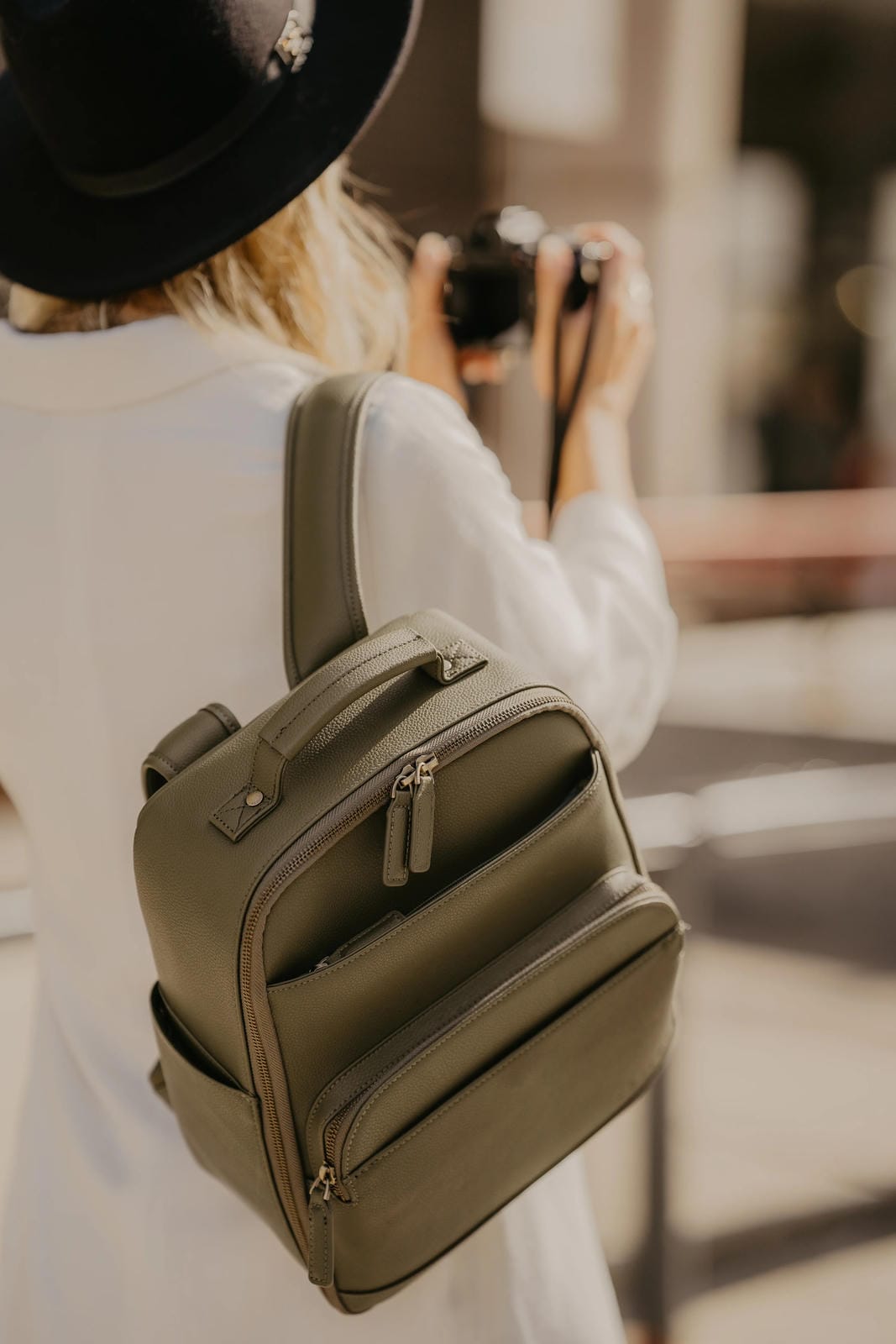 Person wearing a green backpack with a blurred background
