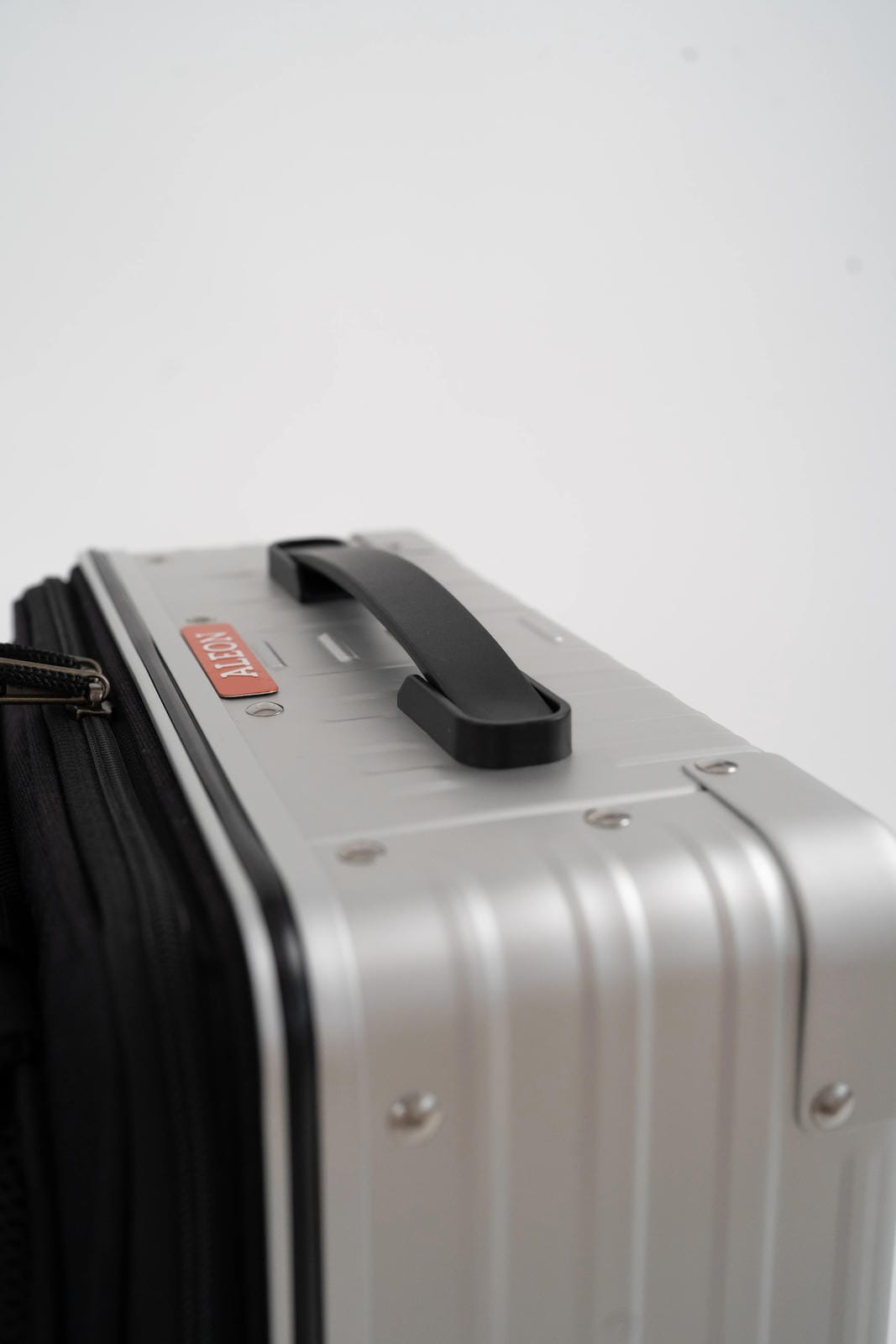 Silver suitcase with a black handle on a white background