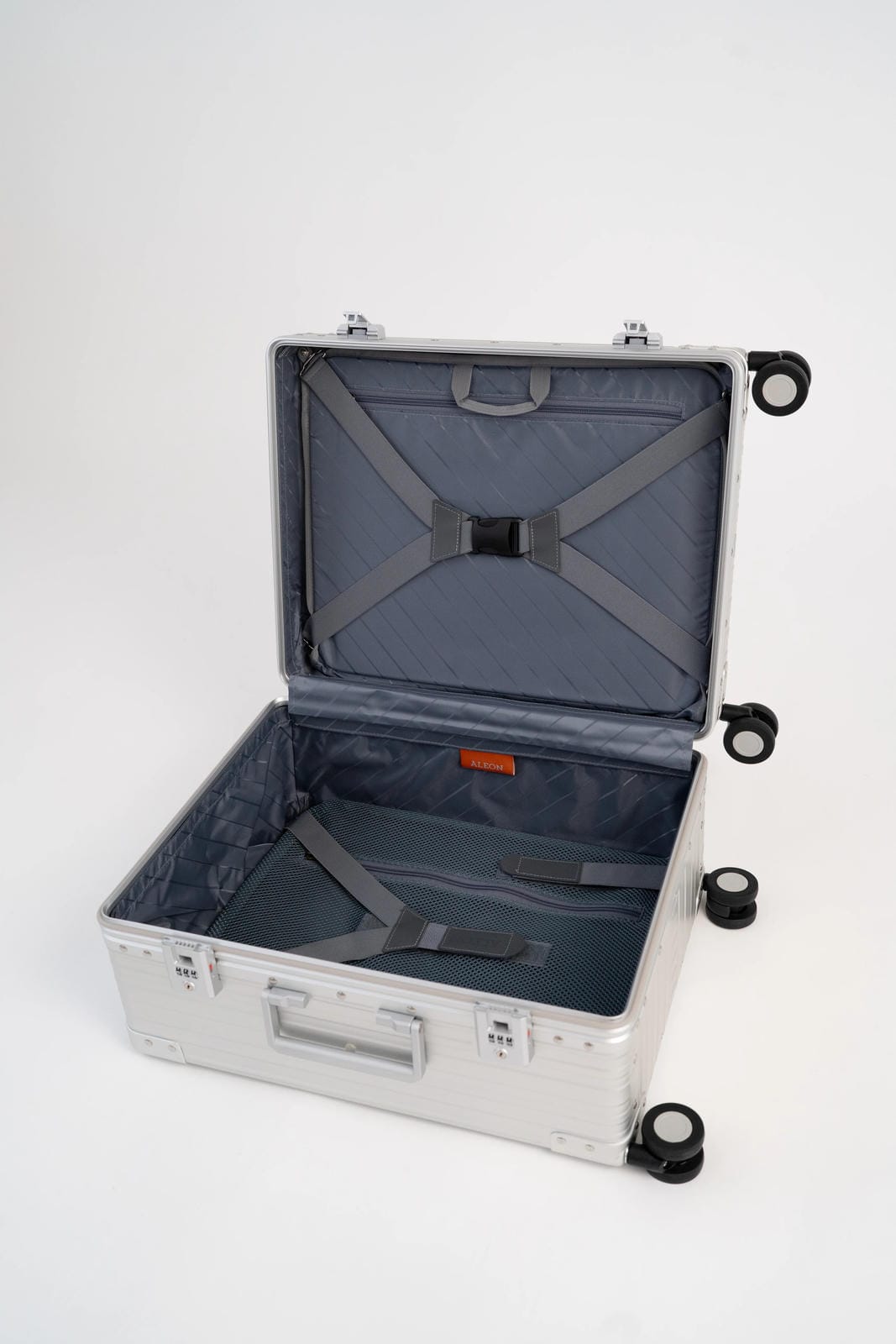 Open silver suitcase with wheels on a white background