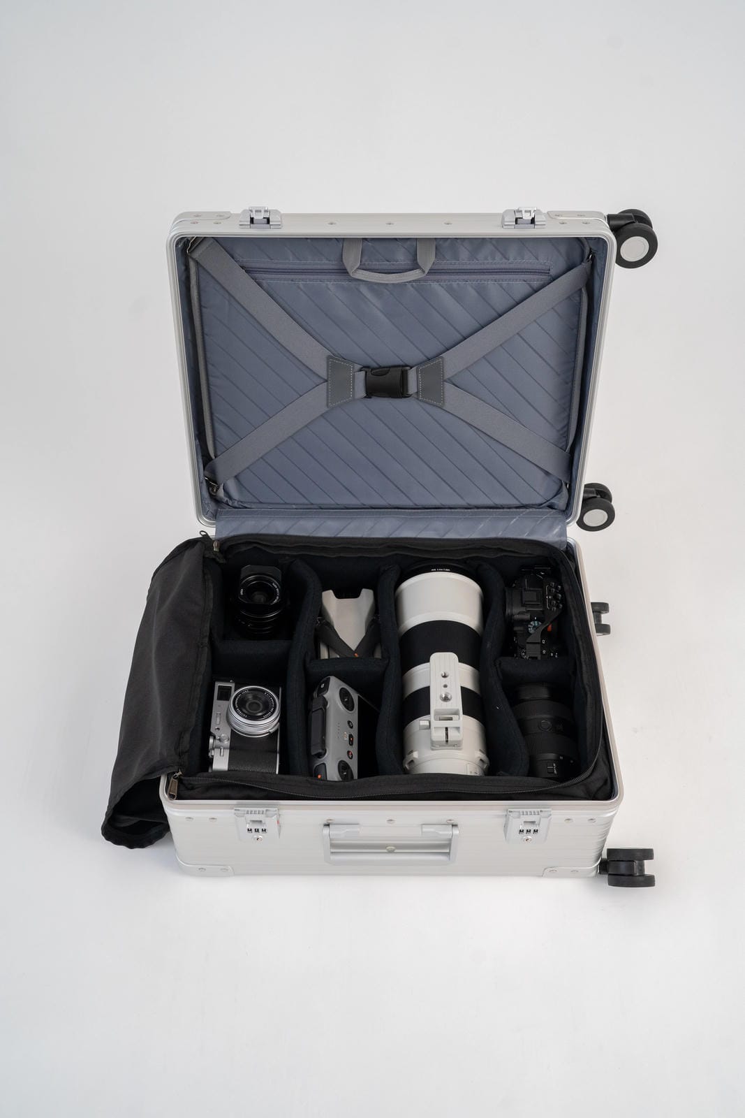 Silver suitcase with camera equipment on a white background