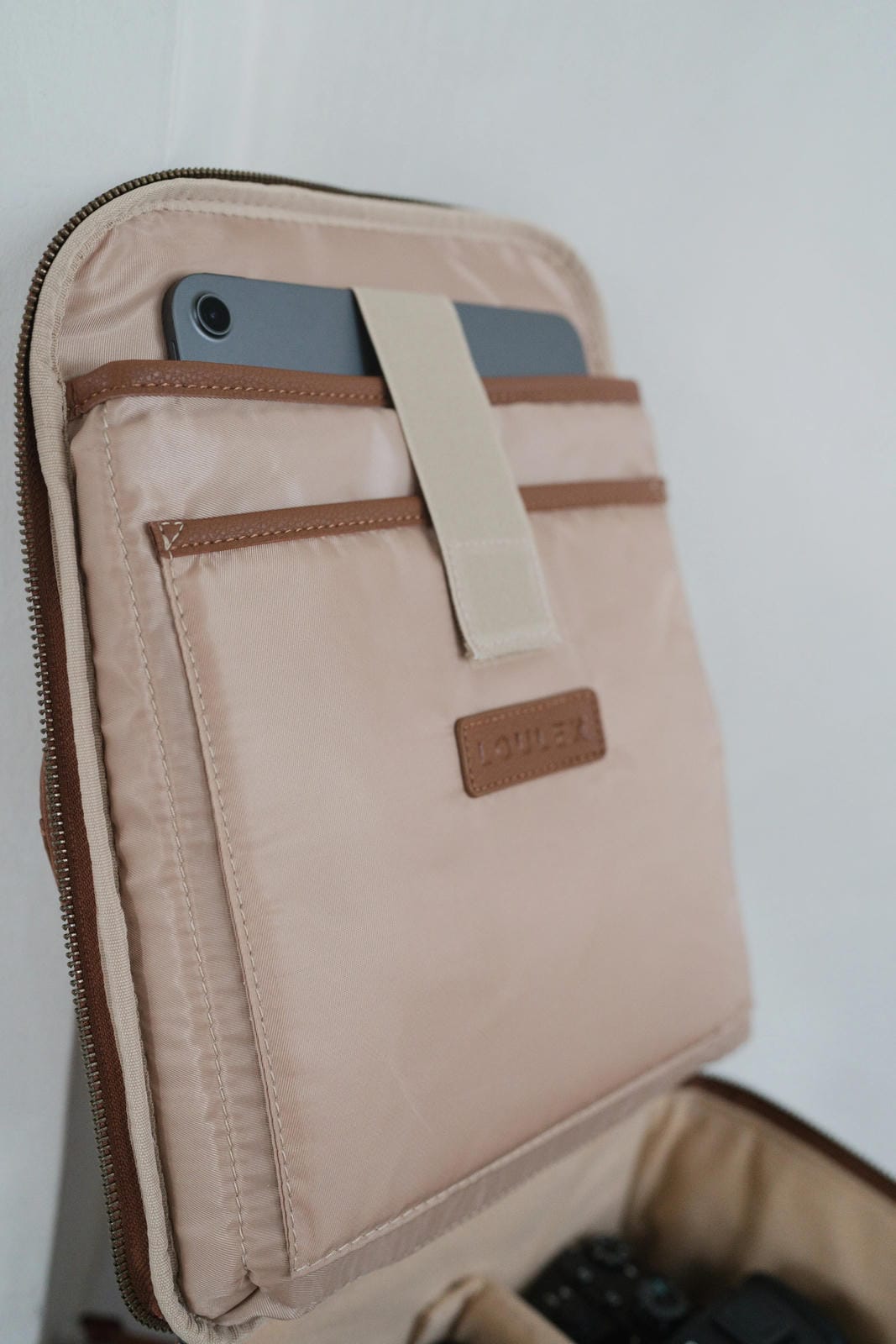Beige travel pouch with a phone inside on a white background