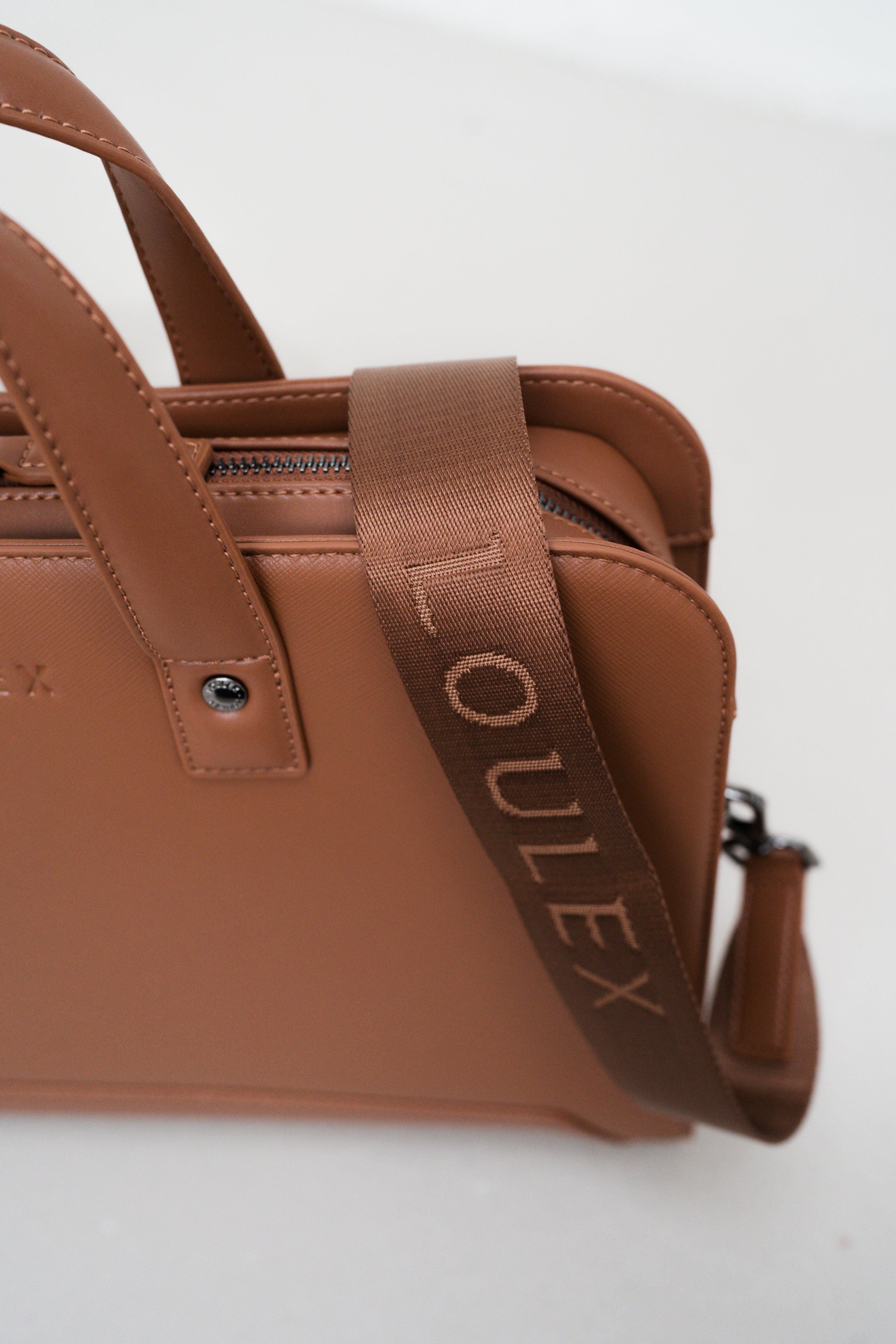 Brown handbag with visible 'Oulex' branding on a white background