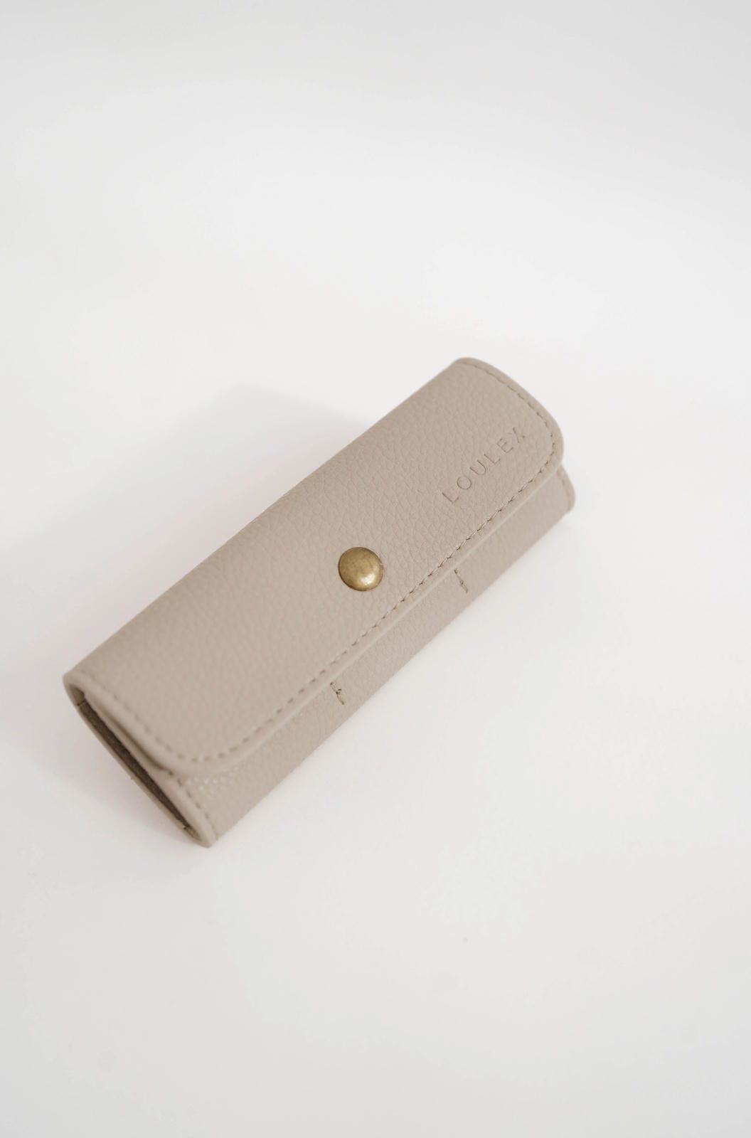 Beige wallet with a gold button on a white background