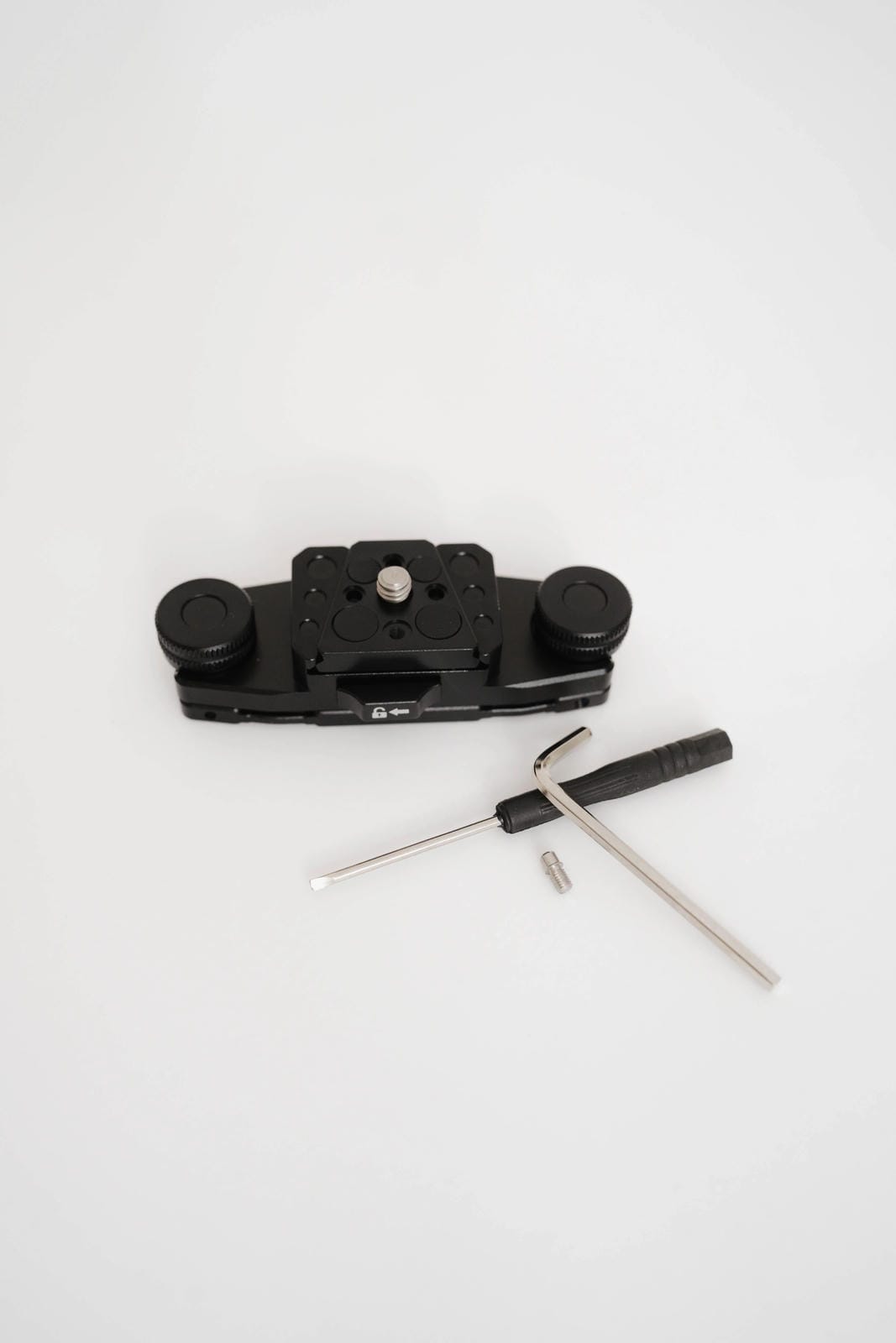 Black camera lens cap removal tool with two screws on a white background