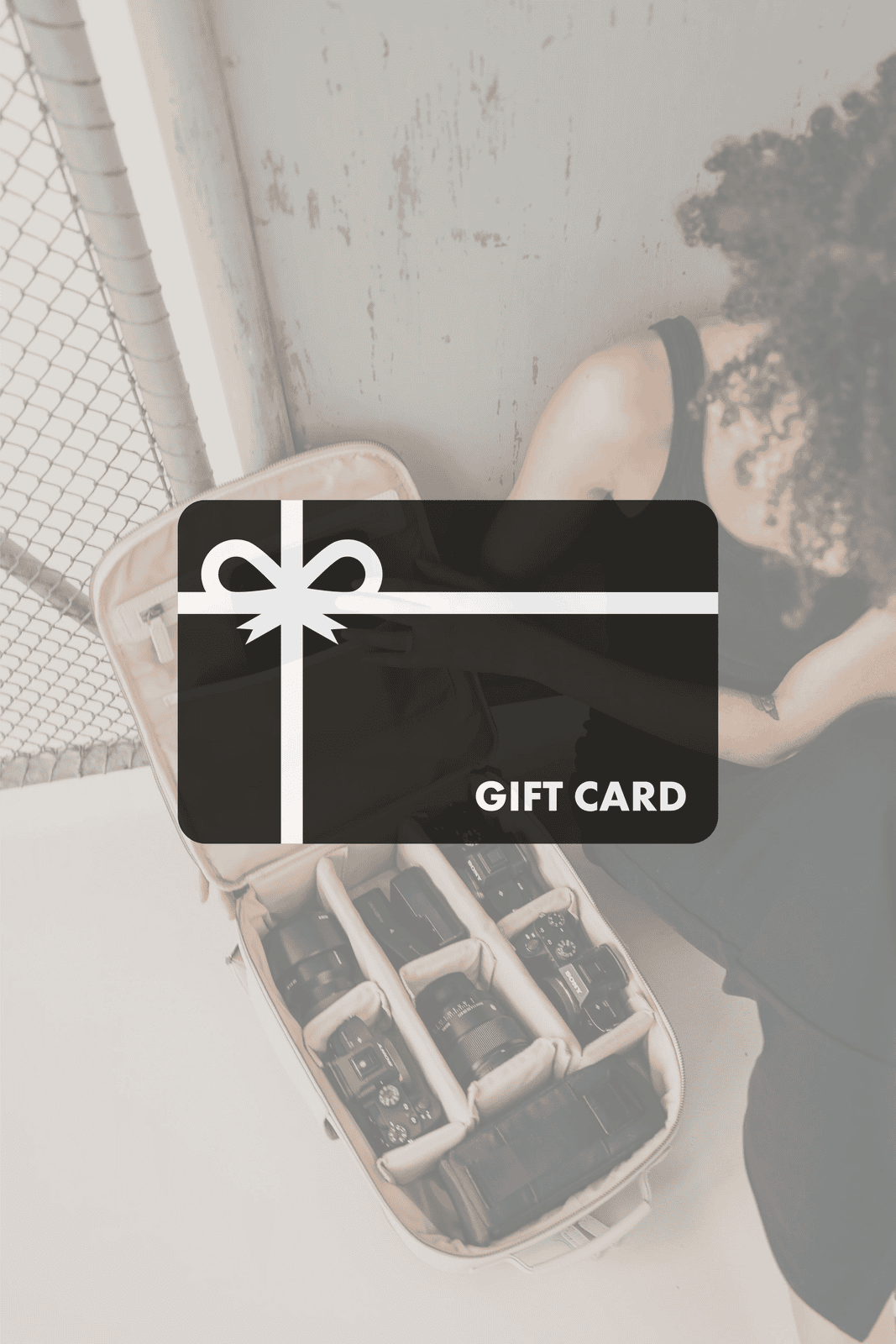 Gift card with a bow design on a blurred background of a person sitting.