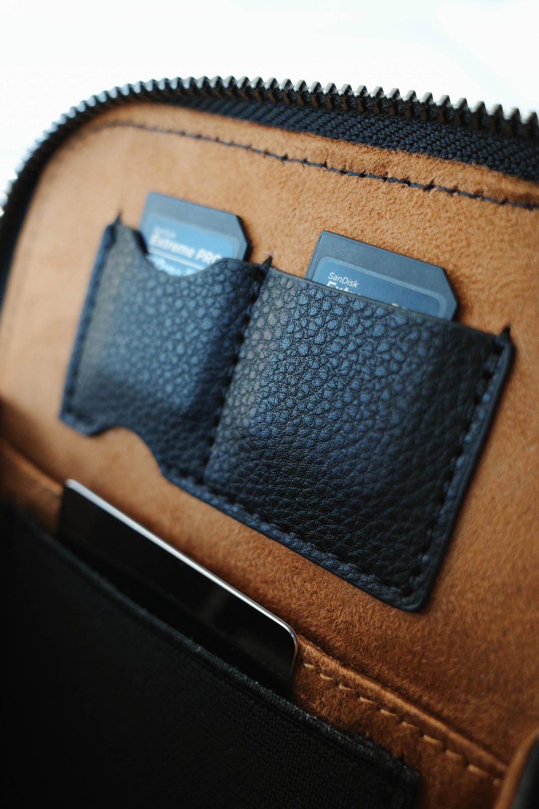 Close-up of a brown leather wallet with card holders and a zipper.