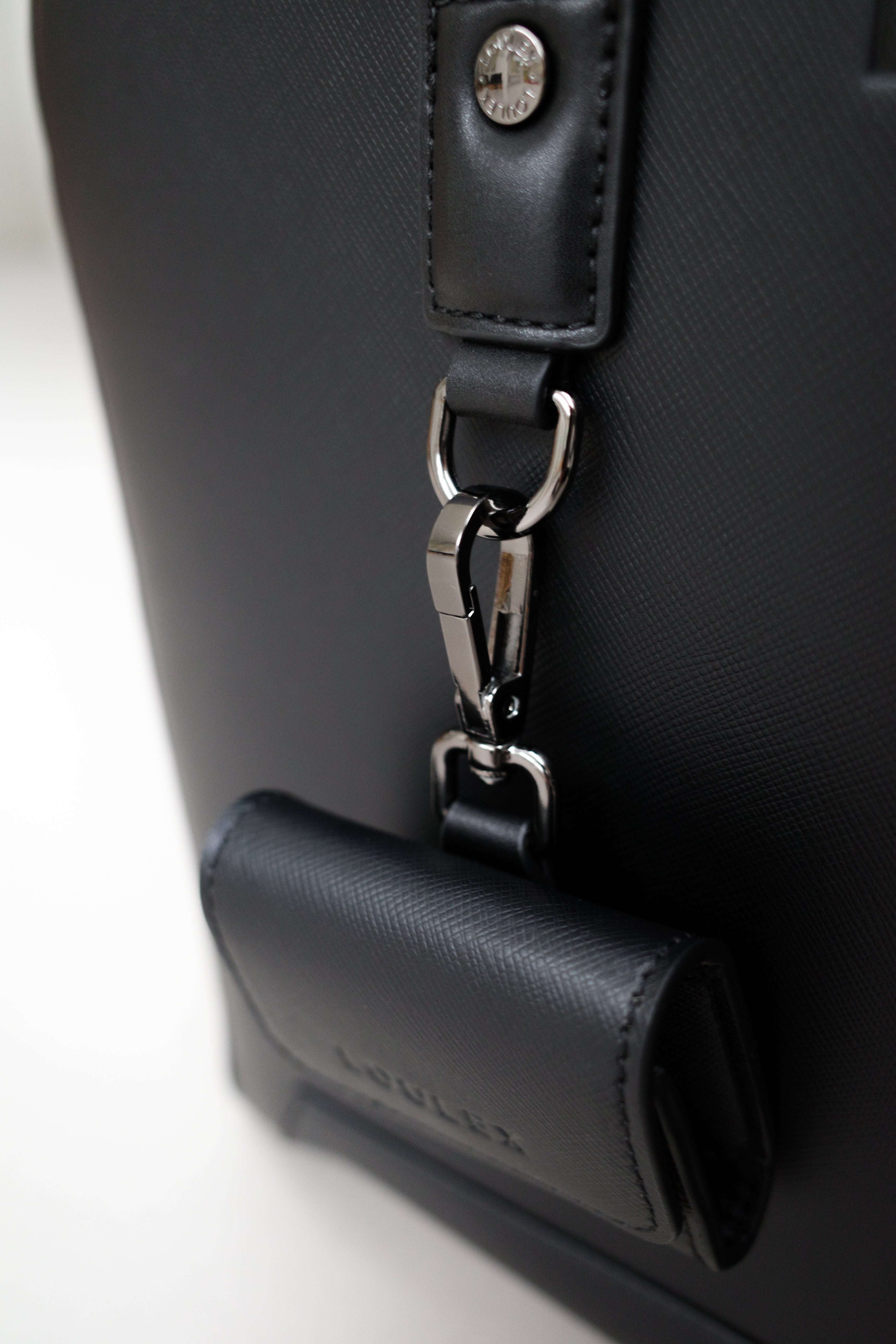 Close-up of a black leather bag with a silver clasp on a white background