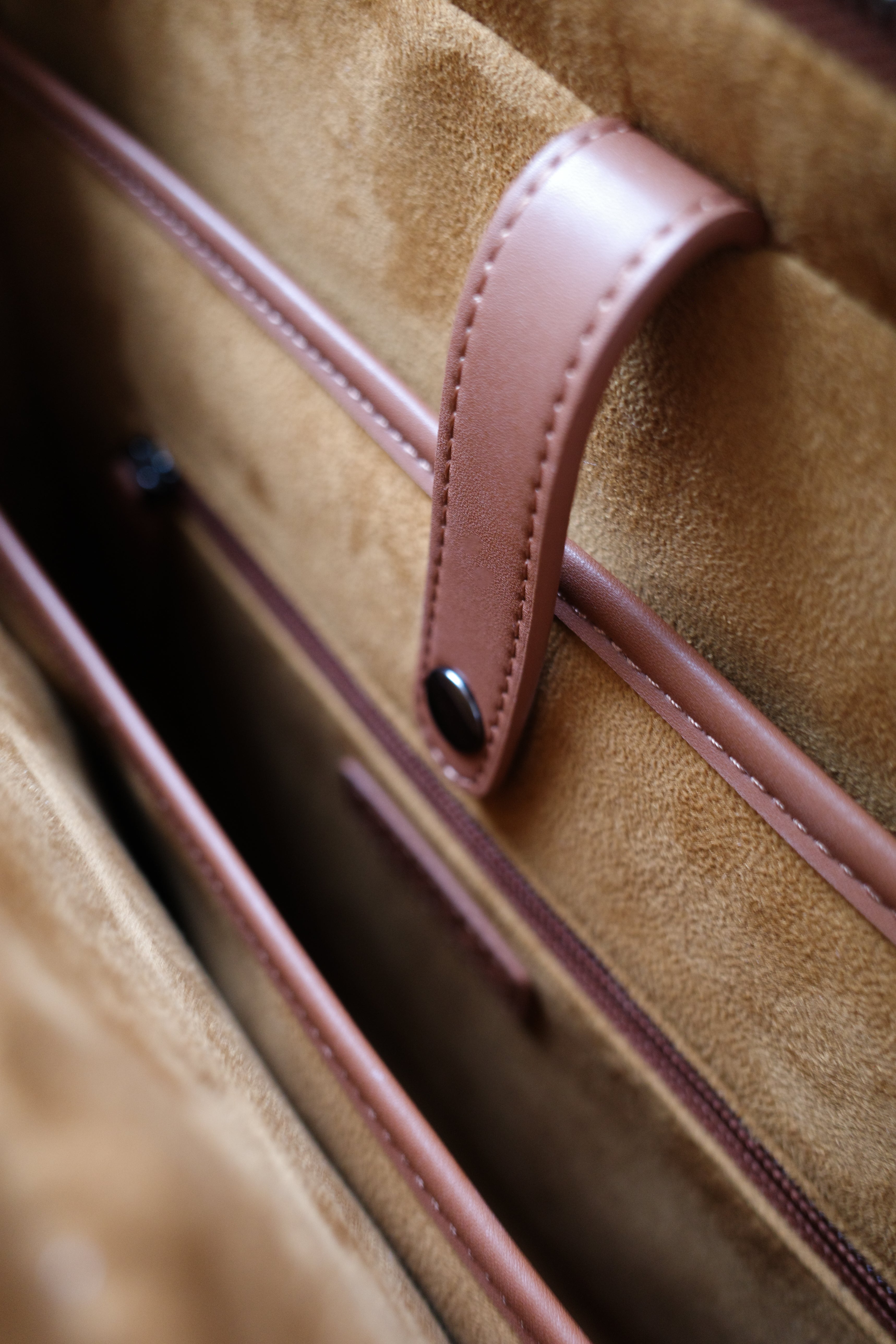 Close-up of a brown leather bag with a strap