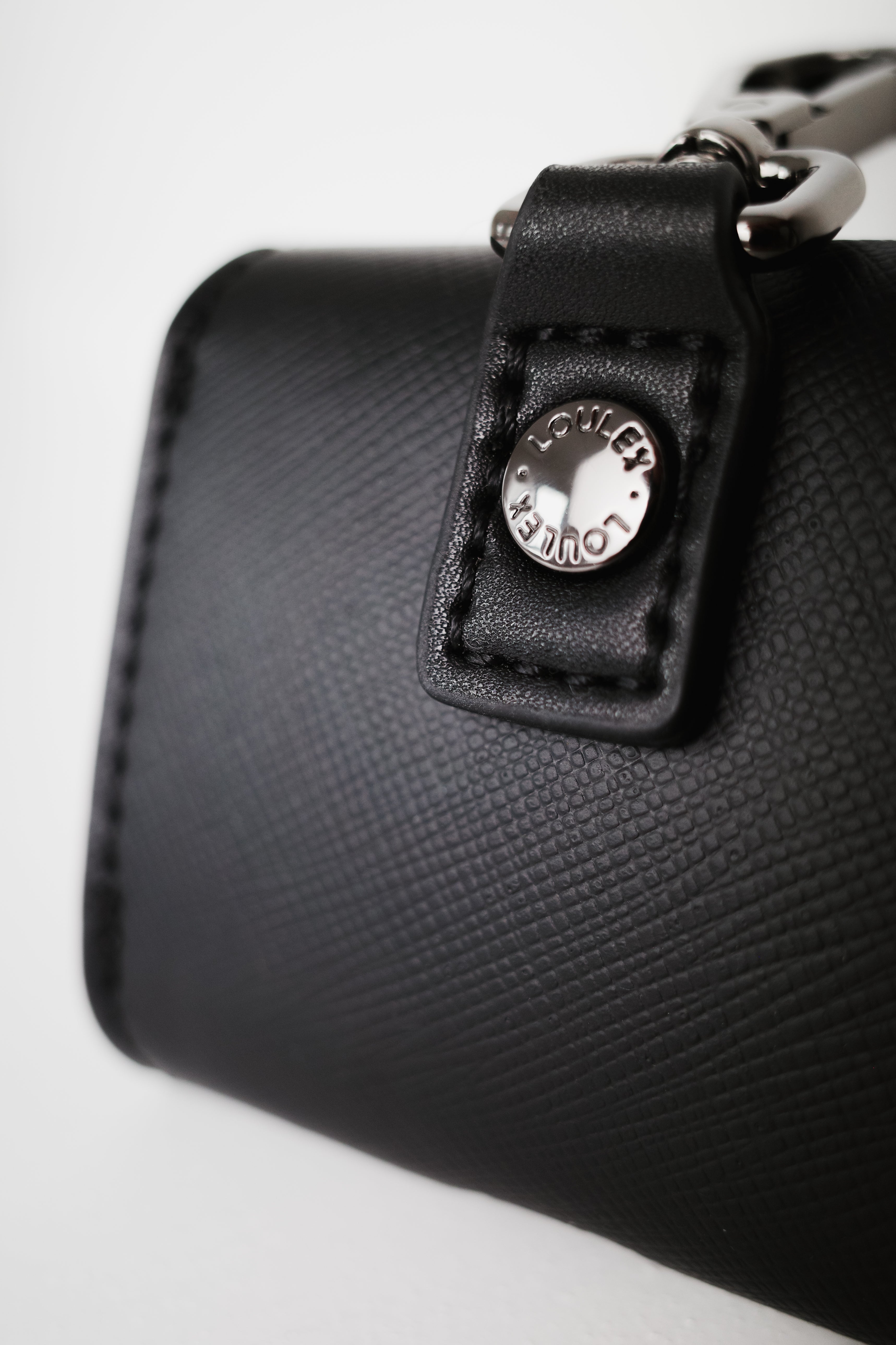 Black handbag with a visible brand logo on a white background