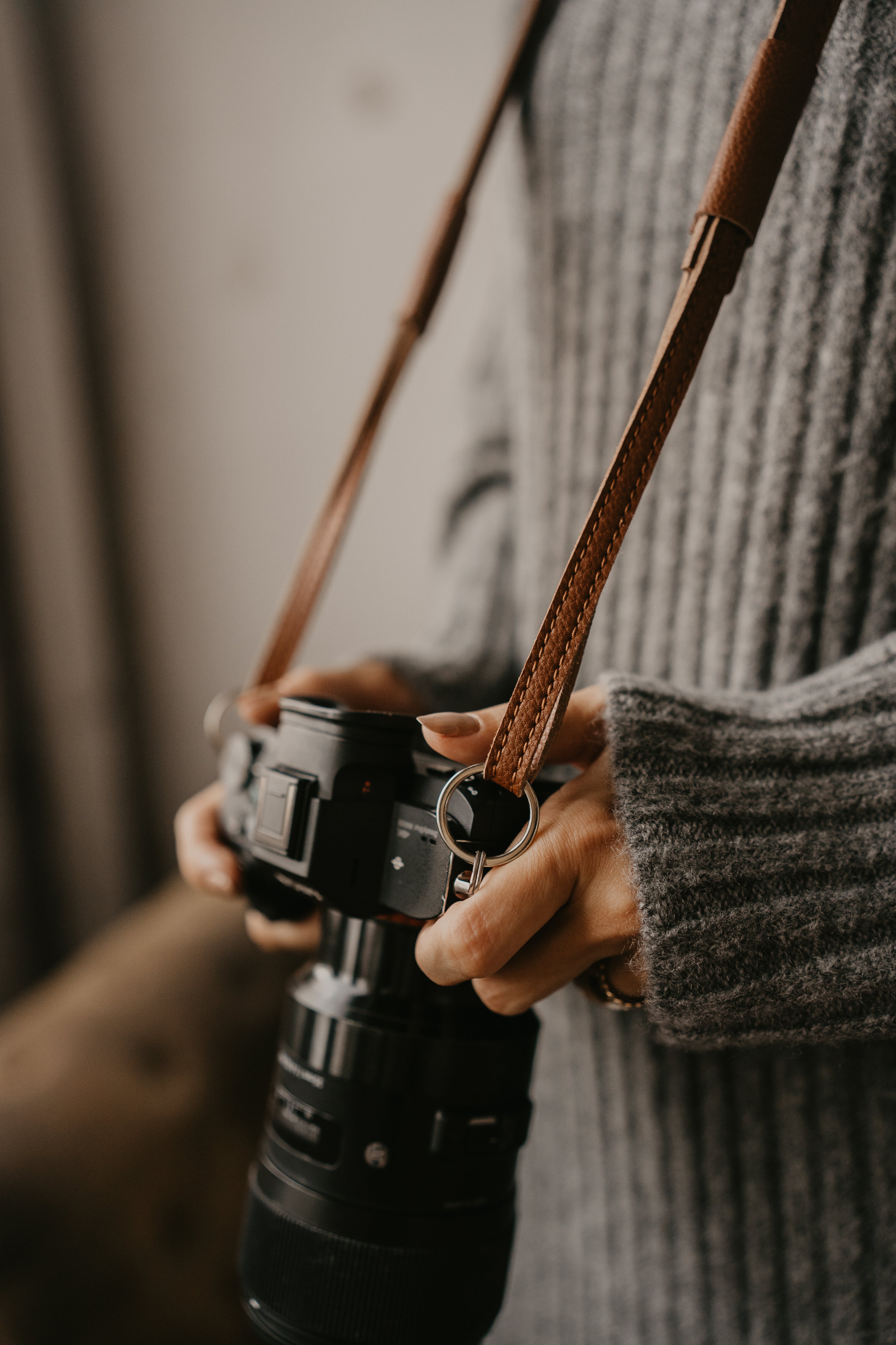 A couple showcasing loulex leather bags, including a beige tote bag for women and a tan leather messenger camera bag.