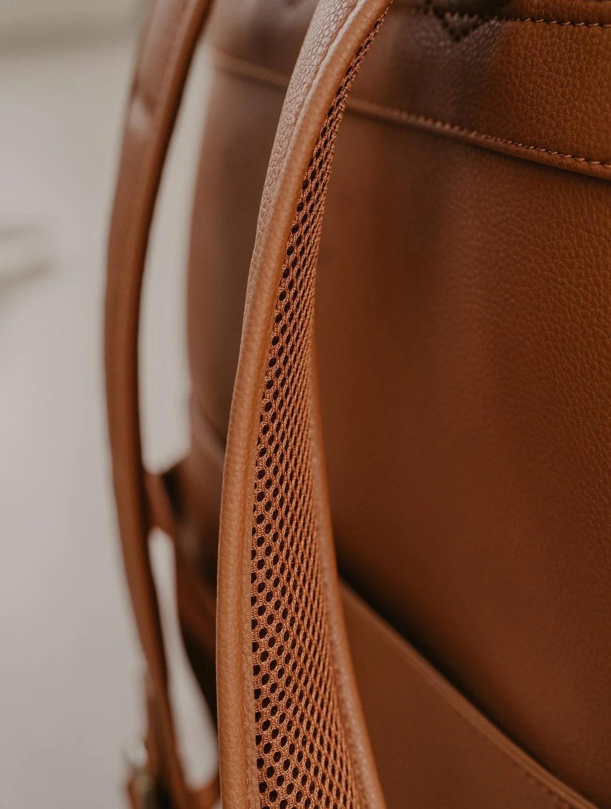 Close-up of a brown leather bag with a textured pattern.