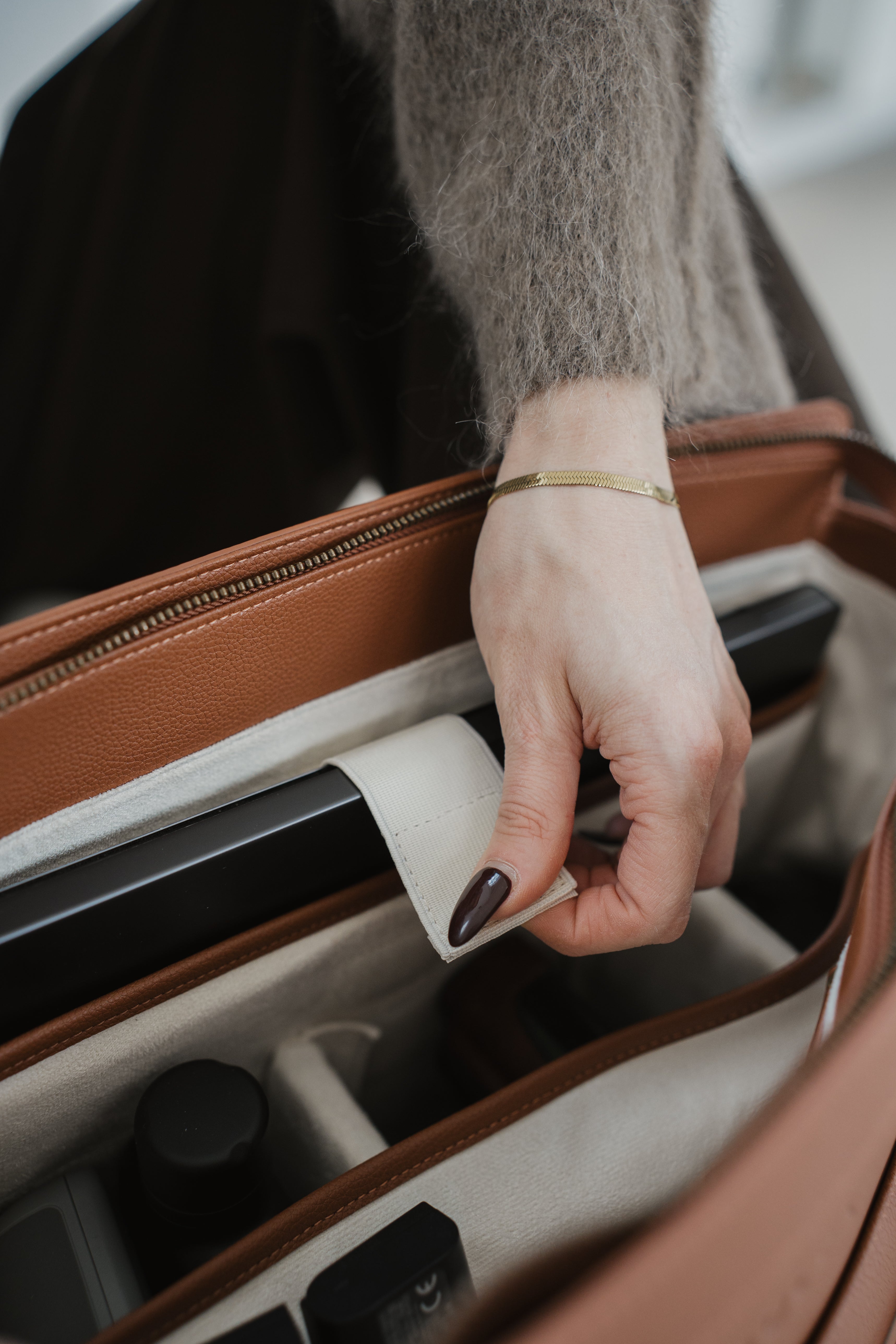 Main ouvrant une valise en mettant l'accent sur l'action de tirer la poignée.