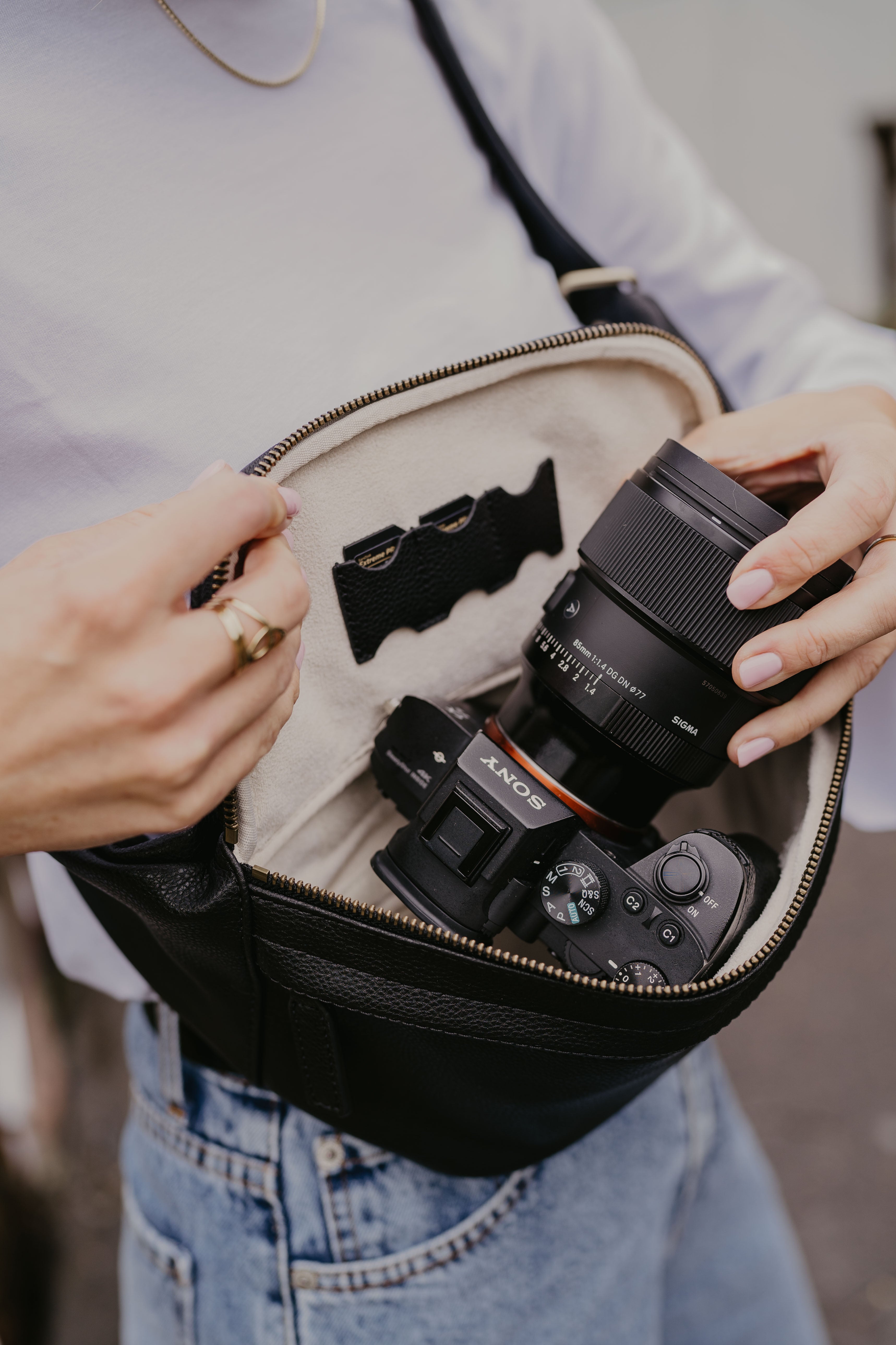 A stylish couple showcasing loulex leather bags: a large cream tote bag for women and a tan leather messenger camera bag for men.