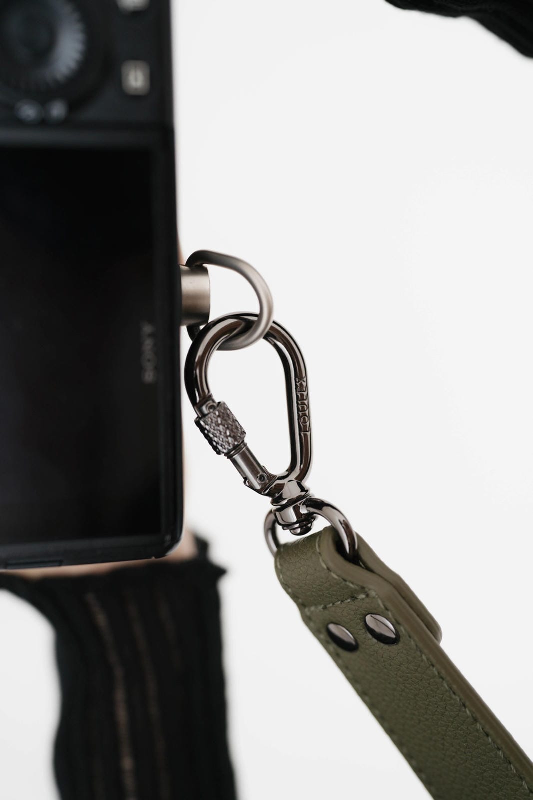Camera with a green strap attached on a white background