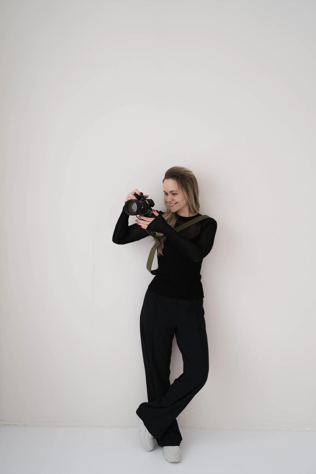 Person holding a camera against a white background