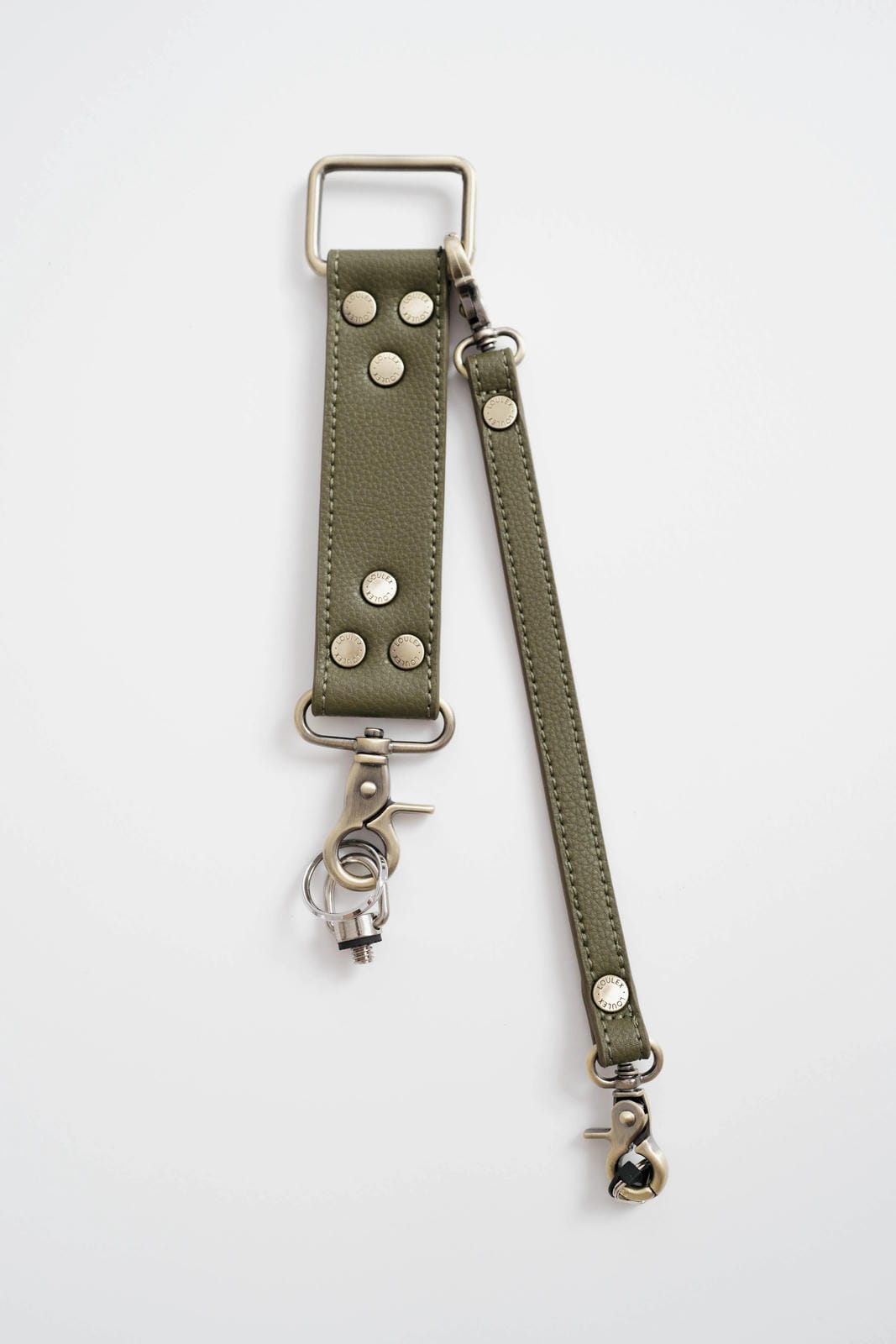 Olive green leather strap with metal hardware on a white background