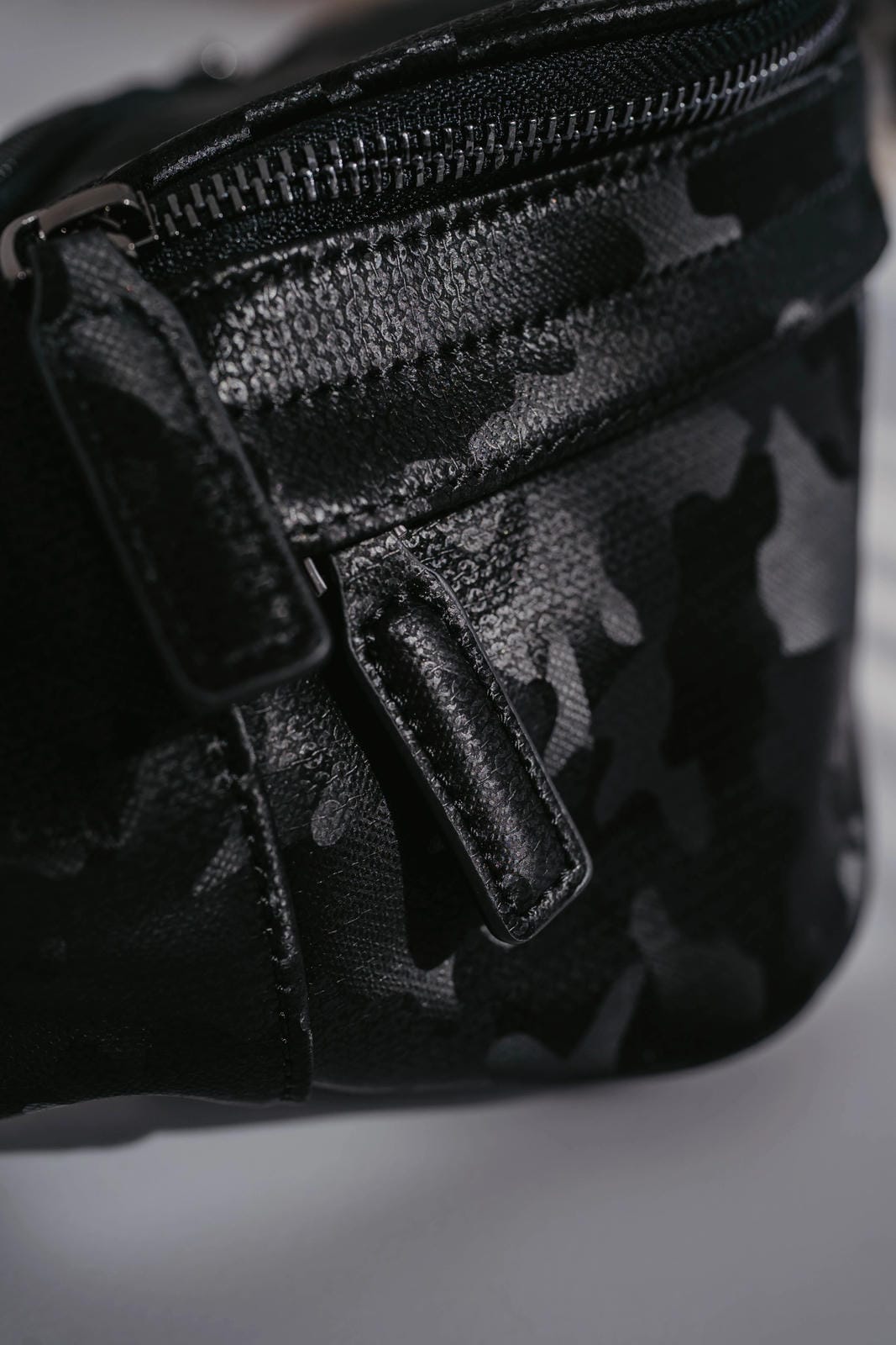 Black camouflage bag with a zipper on a gray background