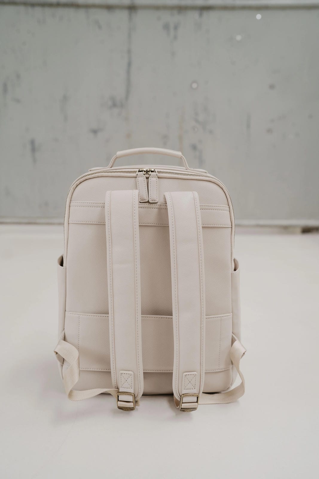 Beige backpack with straps on a light gray background