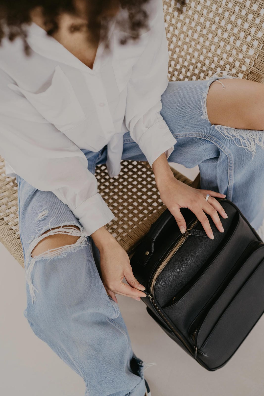 Person holding a black handbag with a blurred background