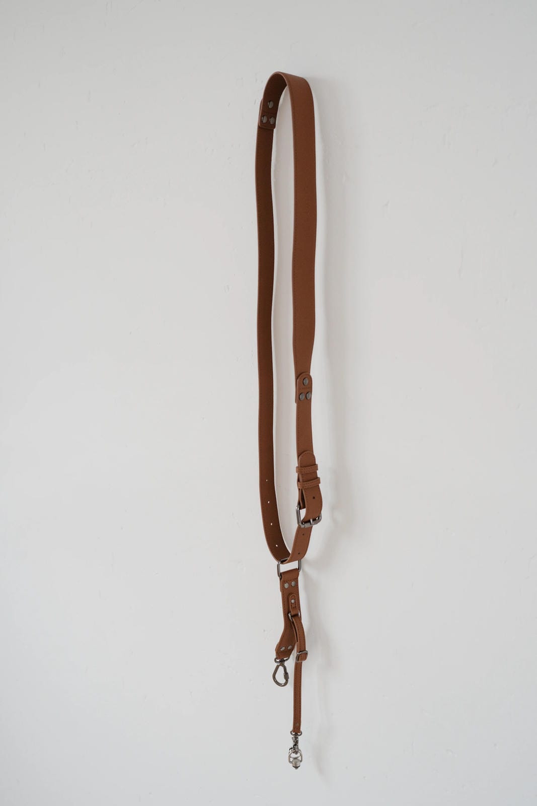 Brown leather strap with metal hardware on a white background