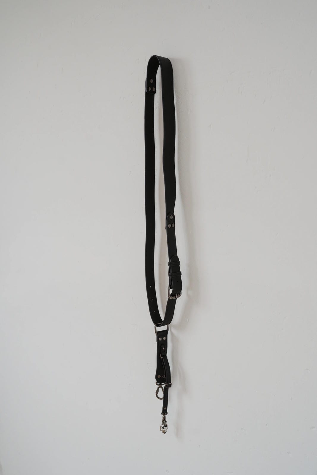 Black leather lanyard with metal clip on a white background