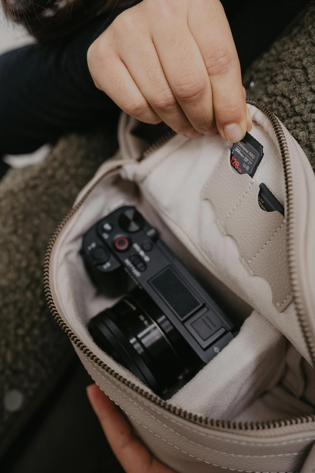 Camera inside a beige pouch held by a person