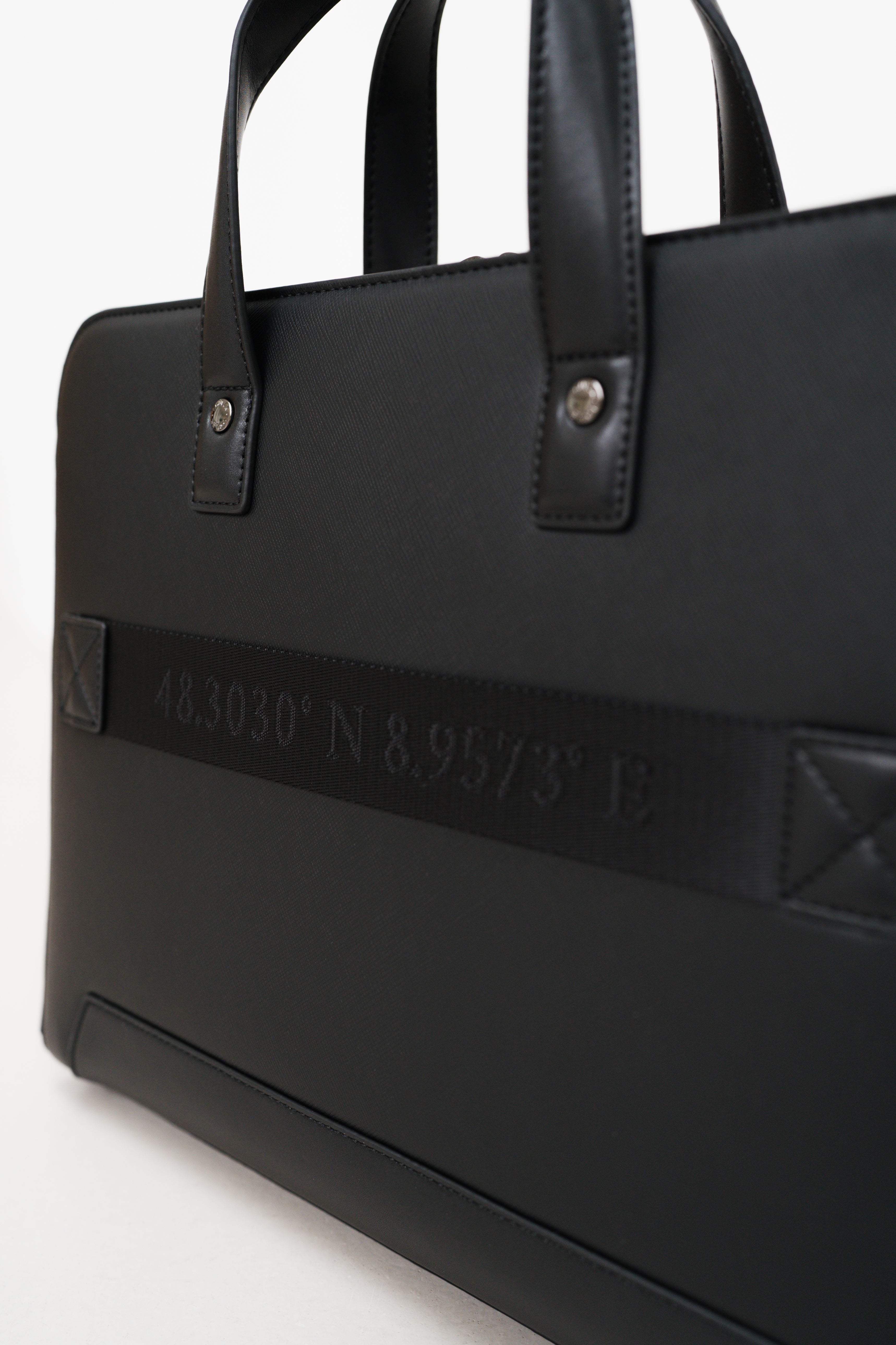 Black leather briefcase with embossed coordinates on a white background