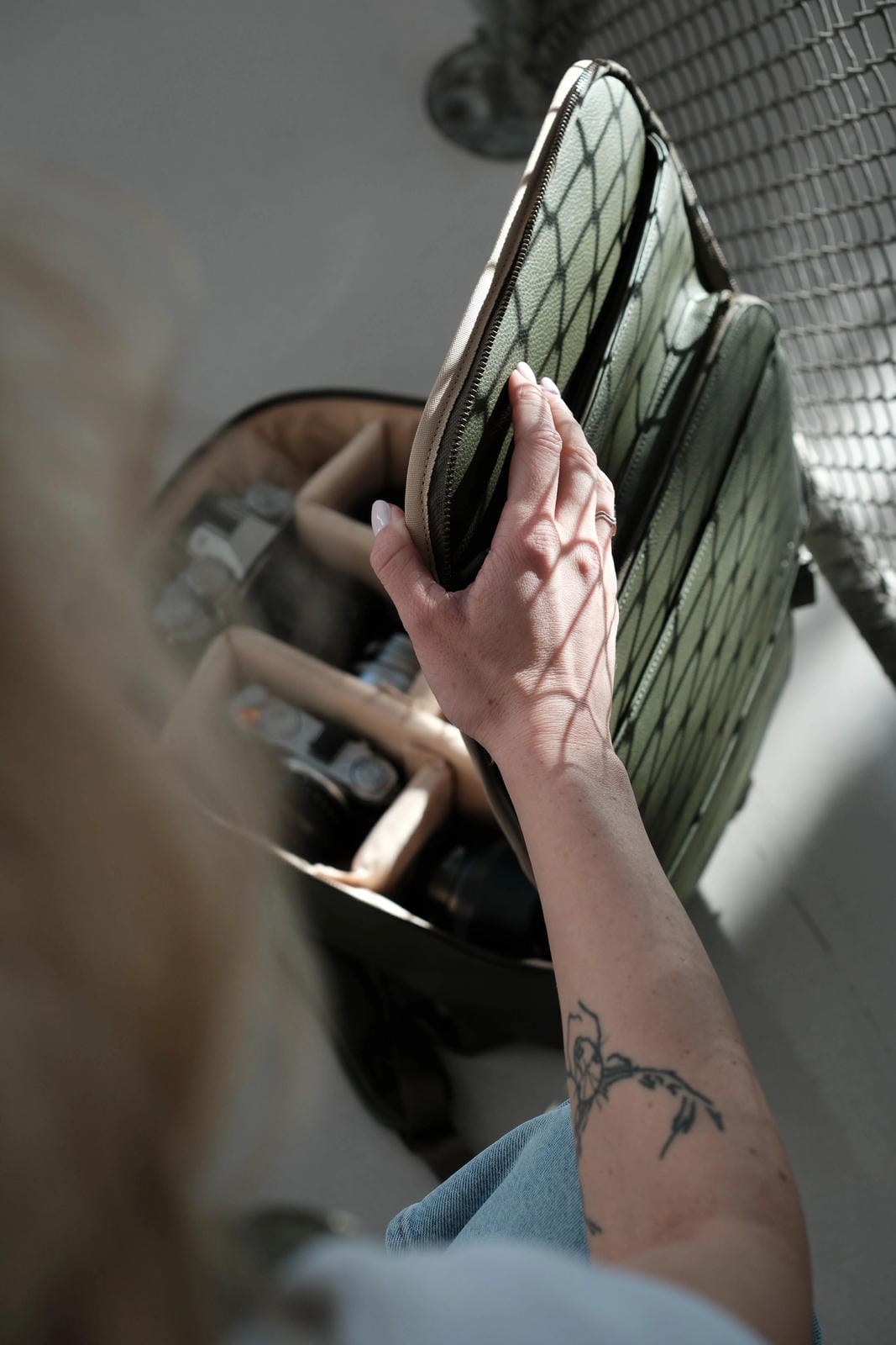 Person holding a green cushion next to a fan