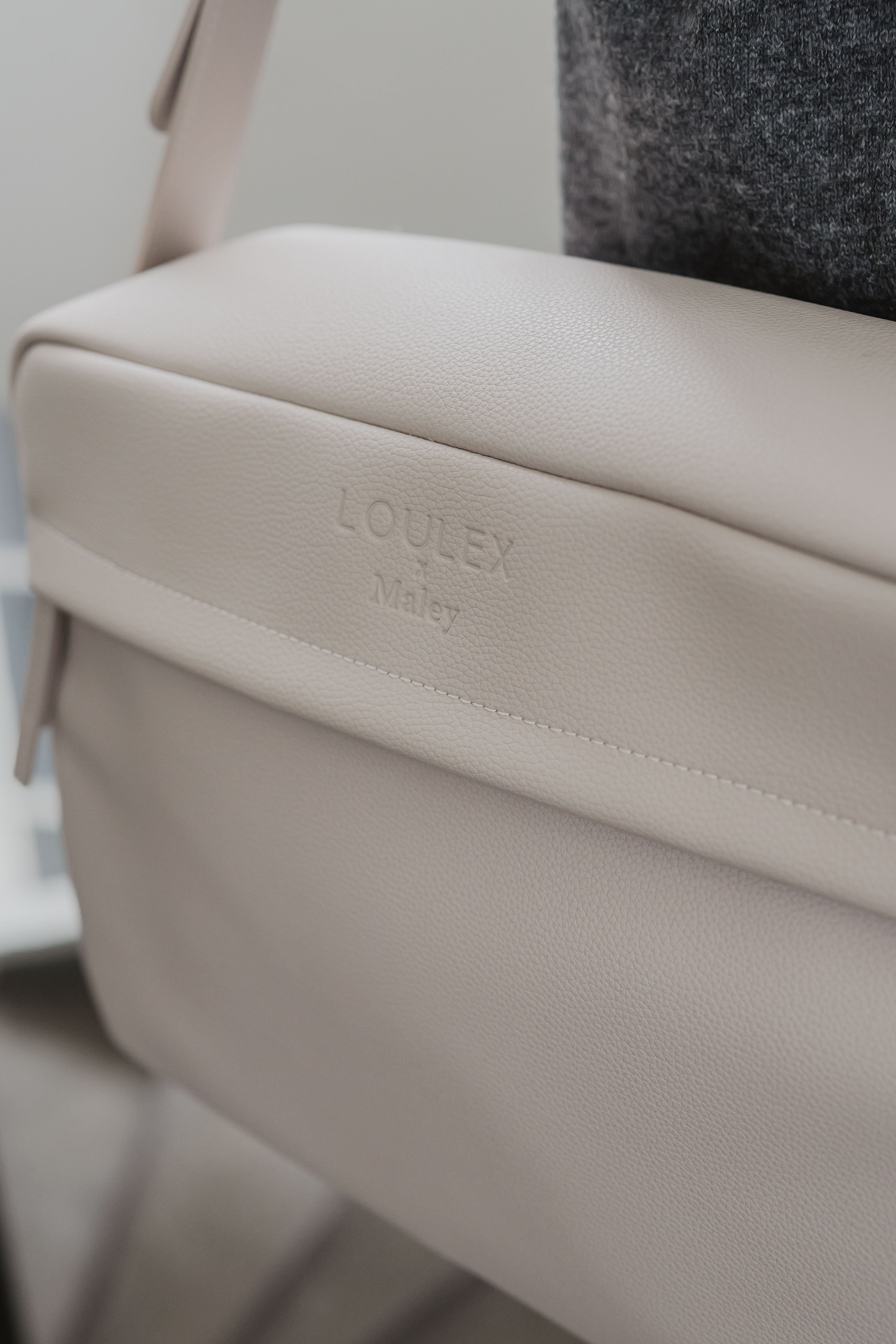 Beige tas met 'LOULEX'-logo op een wazige achtergrond