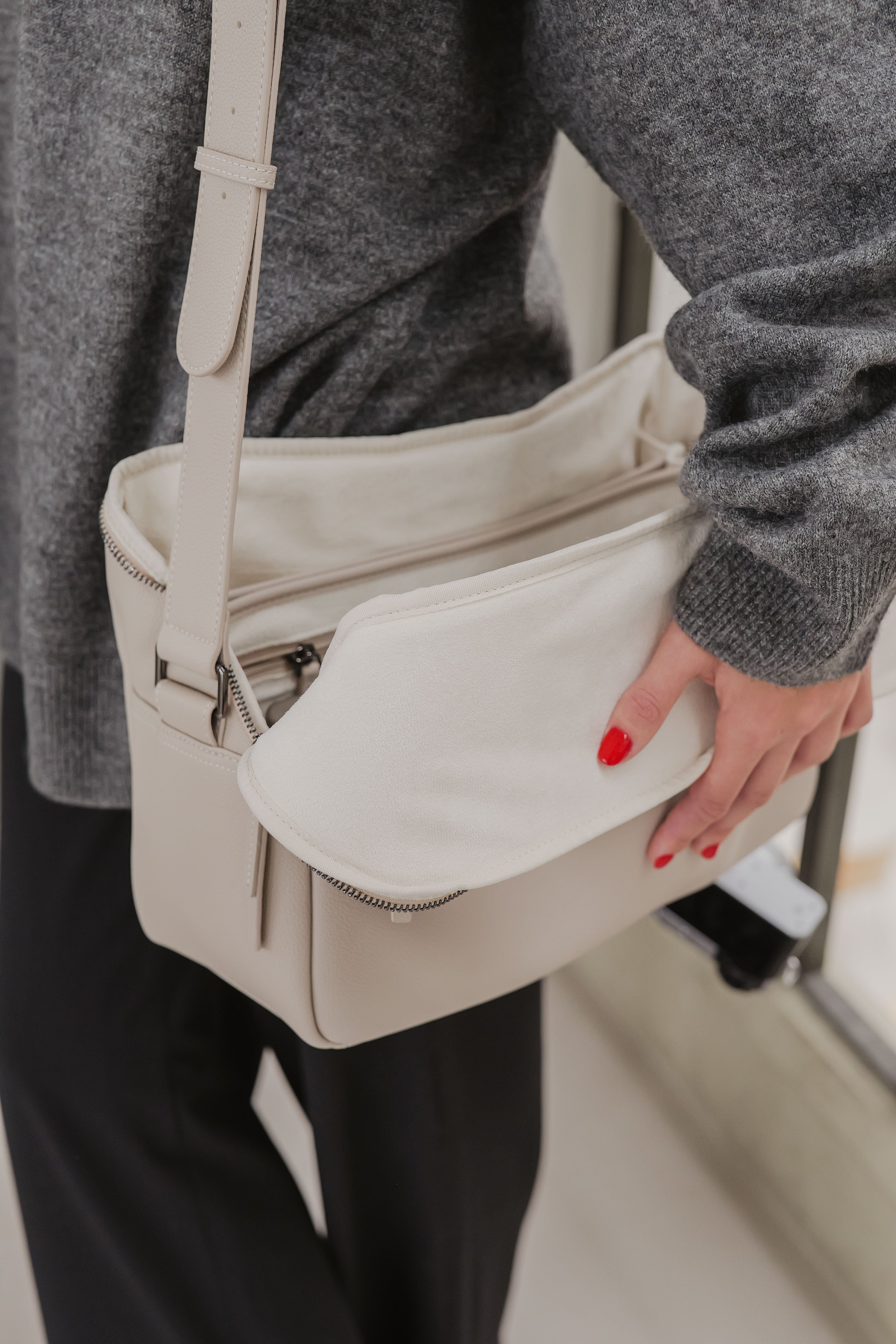 Persoon met een beige handtas en een wazige achtergrond