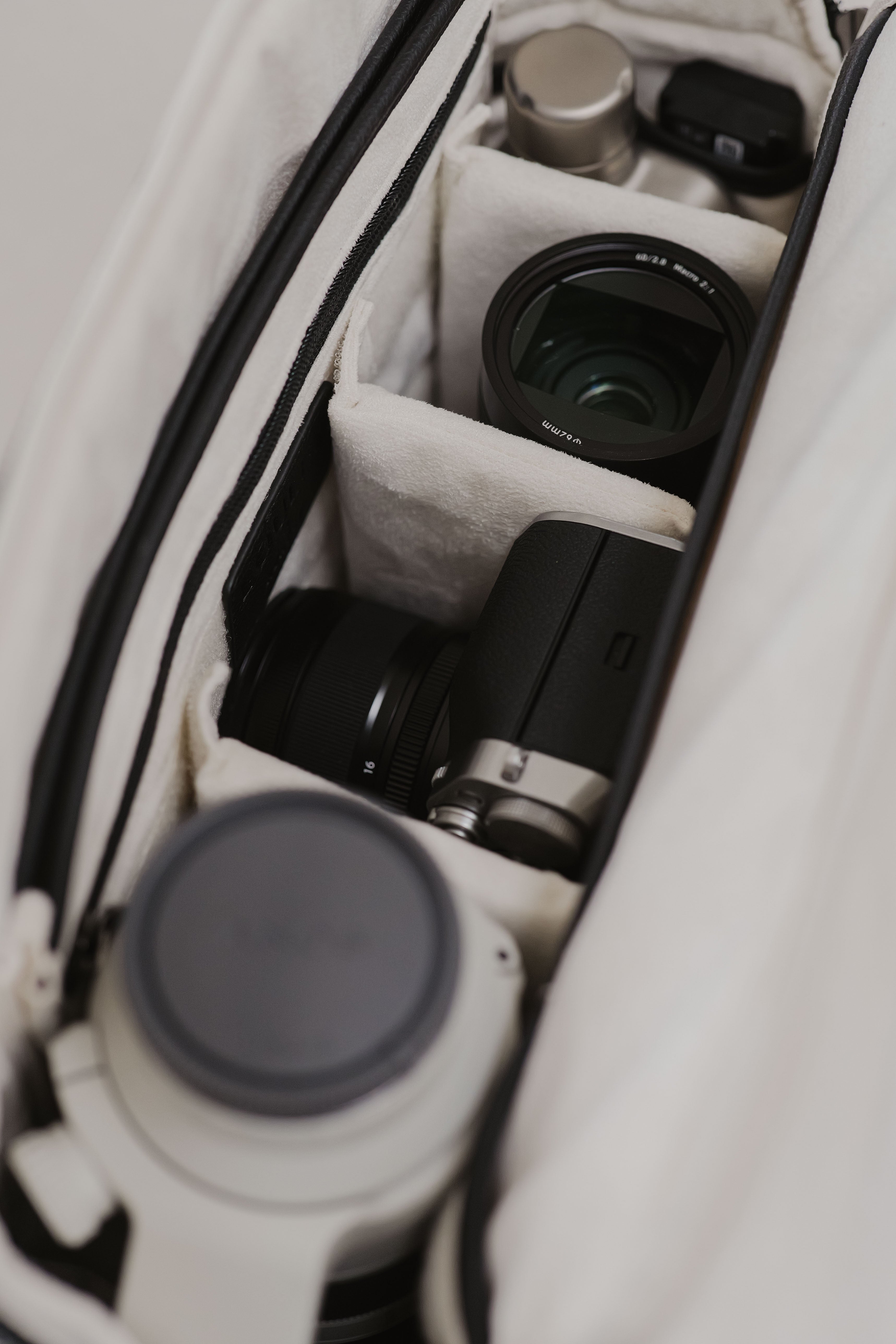 Camera equipment neatly arranged inside a white camera bag