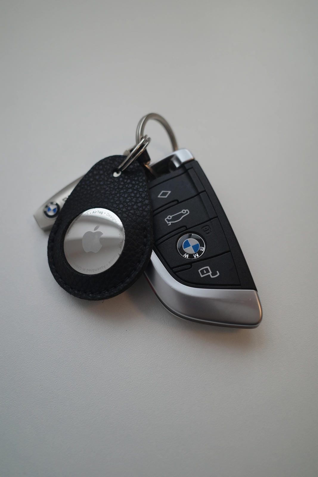 Keychain with Apple and BMW logo on a gray background
